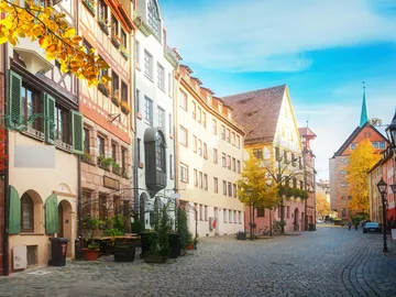 A quiet street with historic buildings and trees.