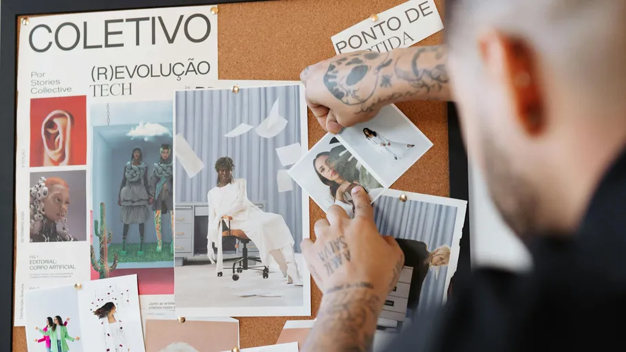 Person pinning photos on a corkboard.