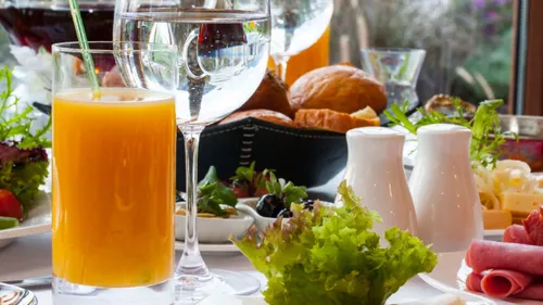 Frühstückstisch mit Saft, Wasser und Essen.
