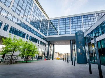 Moderne Gebäude mit Glasfassade und Freifläche im Innenhof.