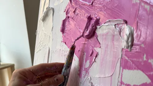 Hand malt mit dicker rosa Farbe auf Leinwand.