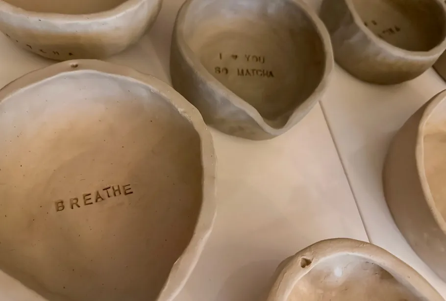 Clay bowls with engraved text on a table.