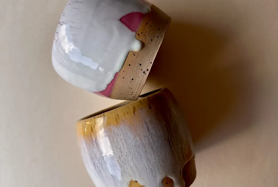 Two ceramic bowls with colorful glazes stacked.