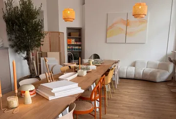 Moderner Speiseraum mit langem Tisch und Stühlen.