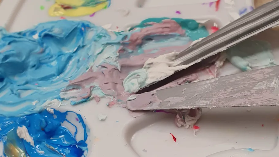 Farbpalette mit Mischmessern und bunter Farbe.