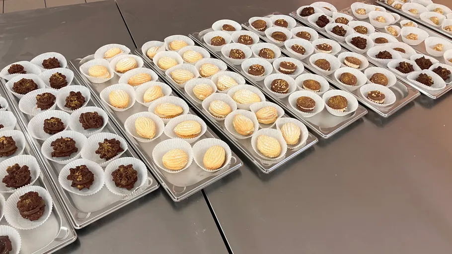 Verschiedene Gebäckstücke auf Blechen in Küche.