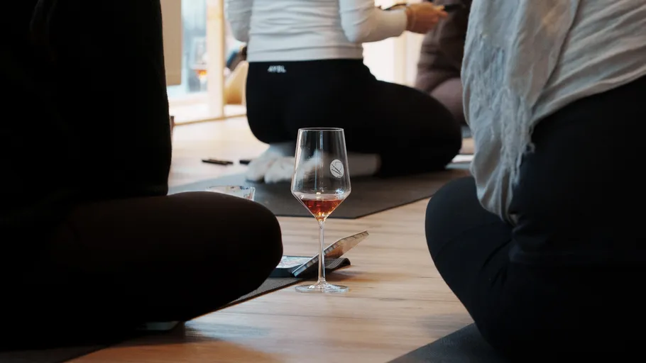 Wine glass on floor in yoga class.