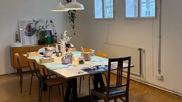 Dining table with art supplies in a room.