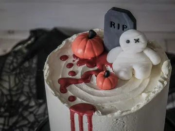 Scary cake with pumpkins and bloody decorations.