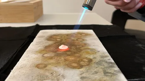 Brenner erhitzt kleines Objekt auf Keramikfläche.