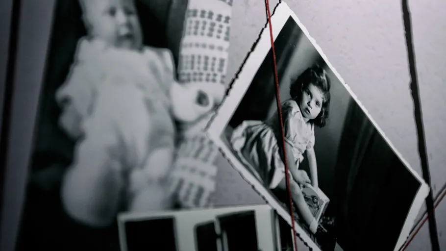 Black-and-white photos stringed on a wall.