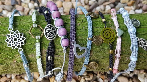 Colorful bracelets displayed on mossy log.