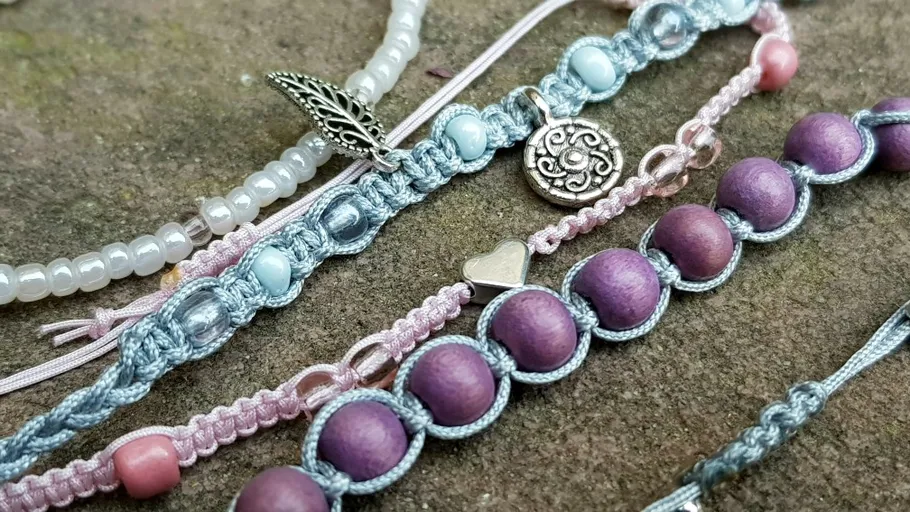 Colorful beaded bracelets on stone surface.