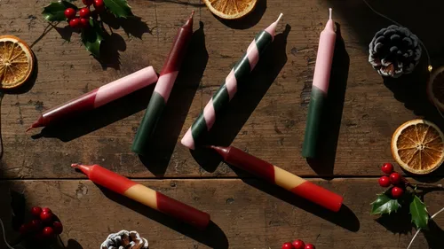Colorful candles on wooden table, holiday decor.