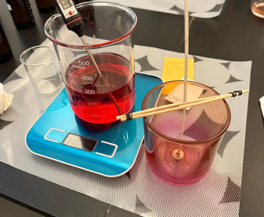 Becherglas mit roter Flüssigkeit und Thermometer auf Waage.