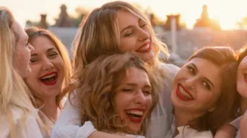 Gruppe von Frauen lacht zusammen draußen.