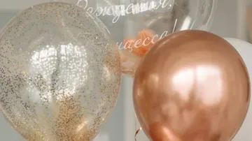 Decorative balloons with glitter and text indoors.