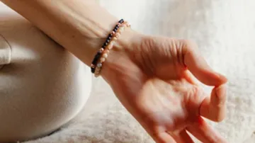Hand ruht auf dem Schoß, meditative Pose.