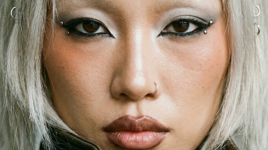 Face with piercings and dramatic eye makeup.