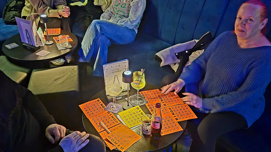 Leute spielen Bingo in einer gemütlichen Lounge.
