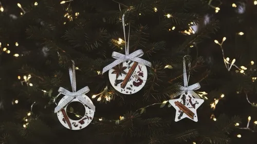 Drei handgemachte Ornamente am Weihnachtsbaum hängend.