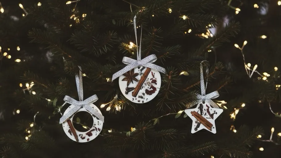 Three handmade ornaments hanging on Christmas tree.