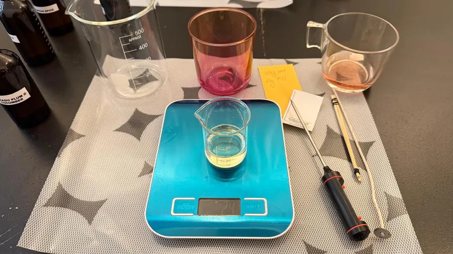 Laboraufbau mit Bechern und digitaler Waage.