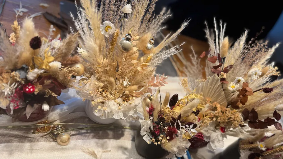 Getrocknete Blumengestecke mit Dekorationselementen.