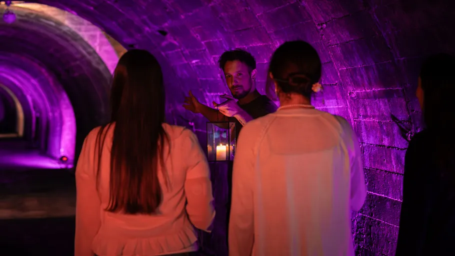 Führer zeigt in schwach beleuchteten Tunnel.