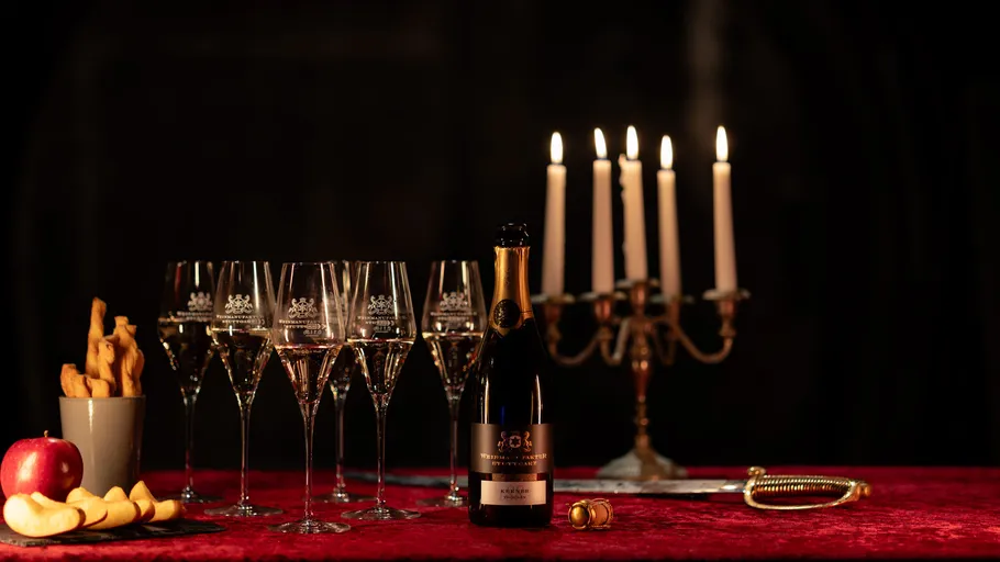 Champagne, flutes, candlelit table with apple slices.