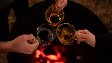 Three cups raised over a fire pit.
