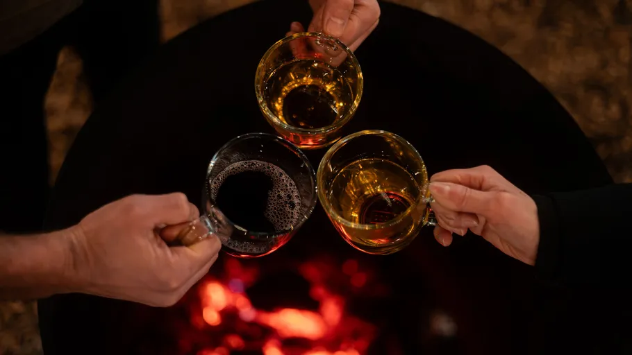 Three cups raised over a fire pit.
