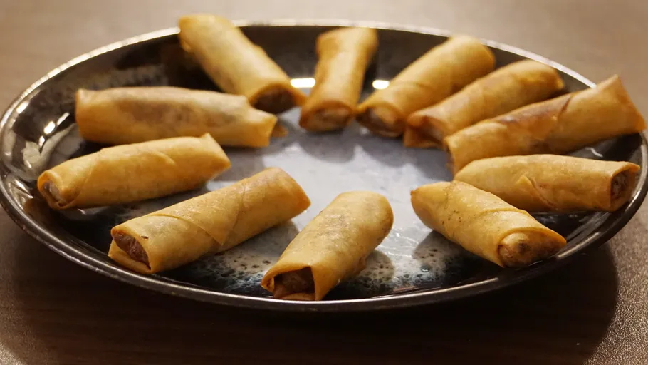 Fried spring rolls arranged on a plate.