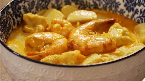 Schüssel mit Garnelen und Nudeln in Currysauce.