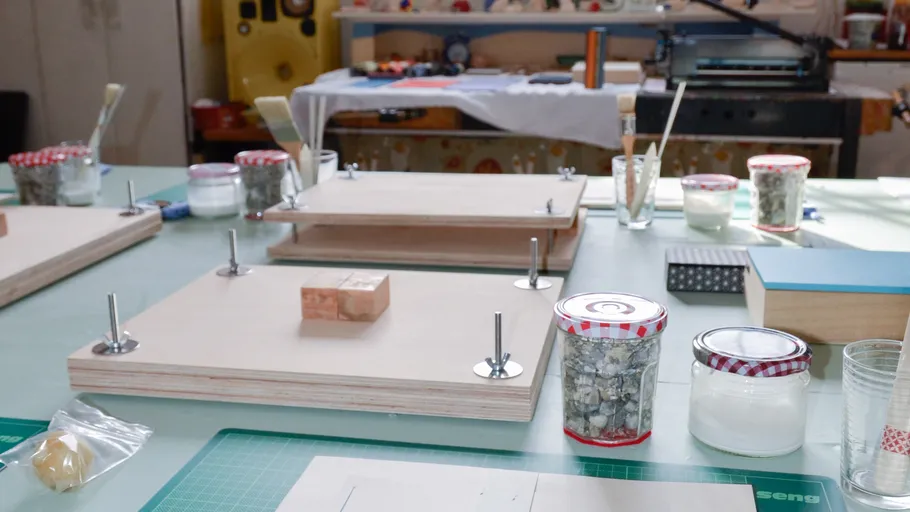 Crafting table with printmaking tools and materials.