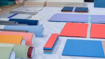Bunte Papierbögen und Rollen auf Tisch ausgestellt.