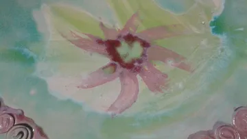 Abstraktes Blumendesign auf Keramikoberfläche.