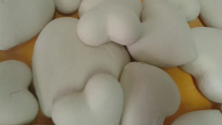 Pile of heart-shaped stones on table.