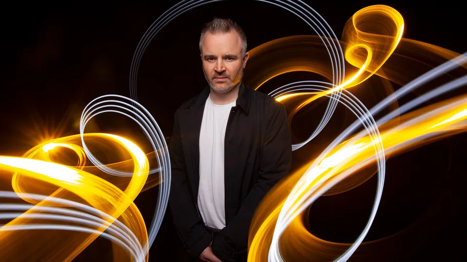 Person posing with swirling light trails.