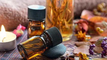 Aromatherapieöle auf Stoff mit Kerzen.