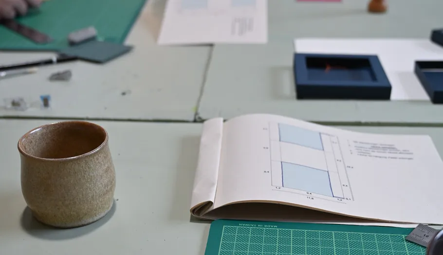 Offenes Buch und Tasse auf einem Tisch.