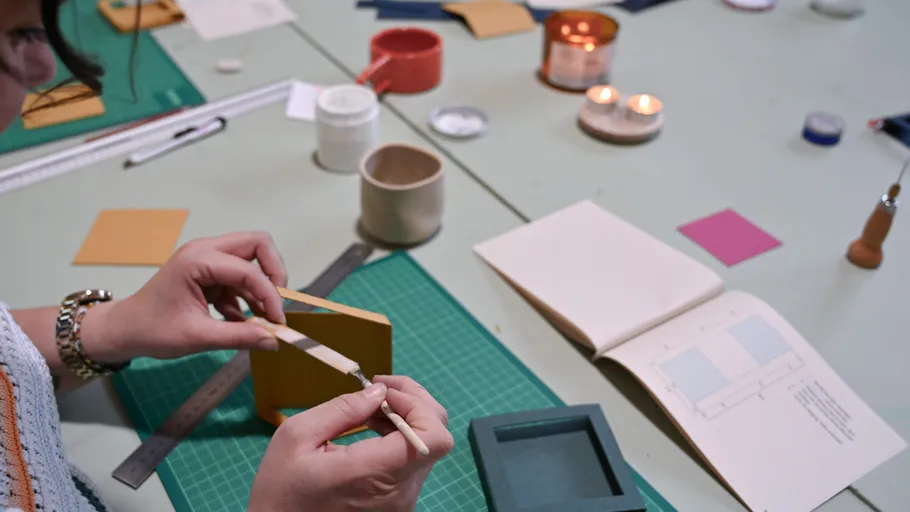 Person crafting box on a worktable.