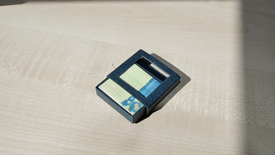 Small black box with colored labels on table.