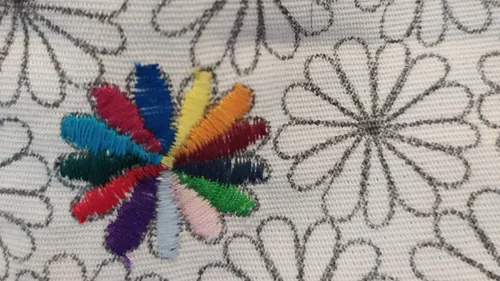 Colorful embroidery on patterned fabric background.
