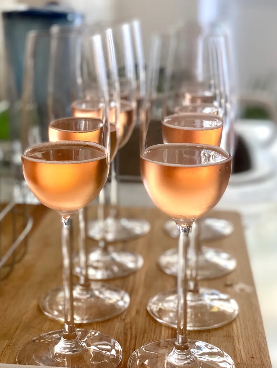 Rows of filled wine glasses on countertop.