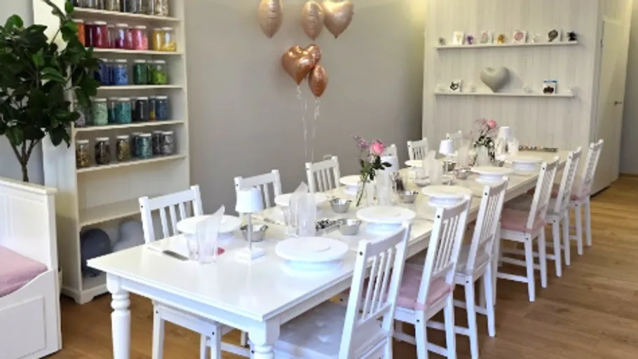 Dekorierter Esstisch mit Stühlen und Ballons.