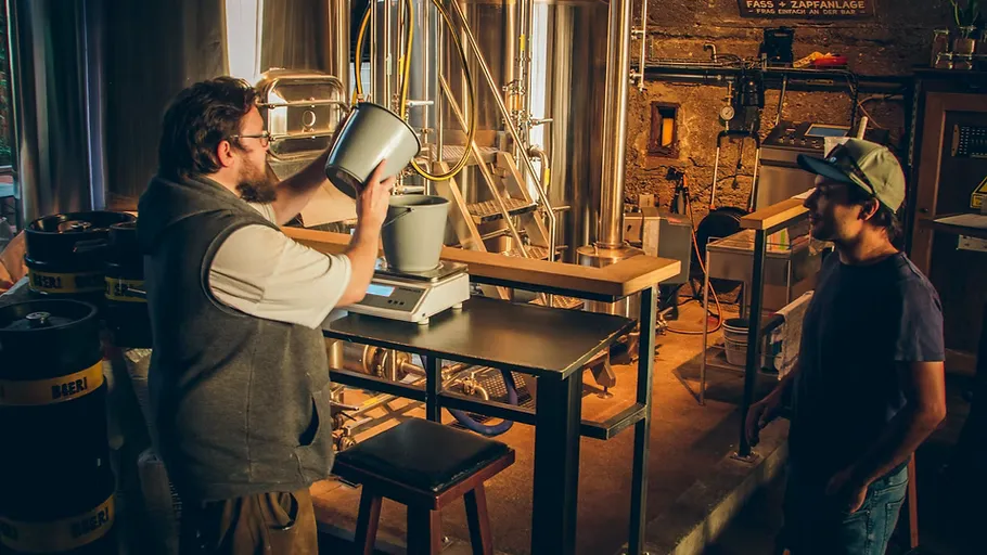 Two men brewing beer in a brewery.