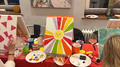 Gemalte Sonne mit bunten Strahlen im Atelier.