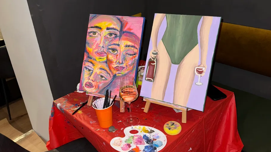 Two colorful paintings on a red table.