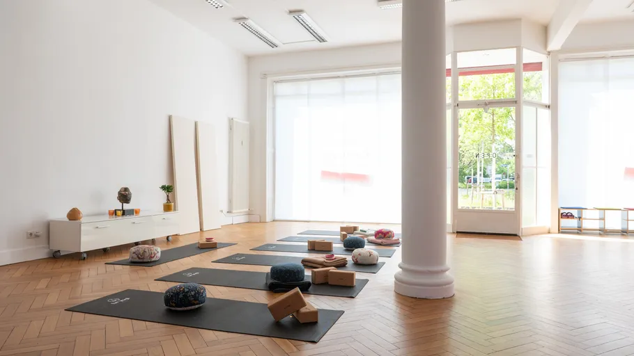 Yoga mats and cushions in bright studio.